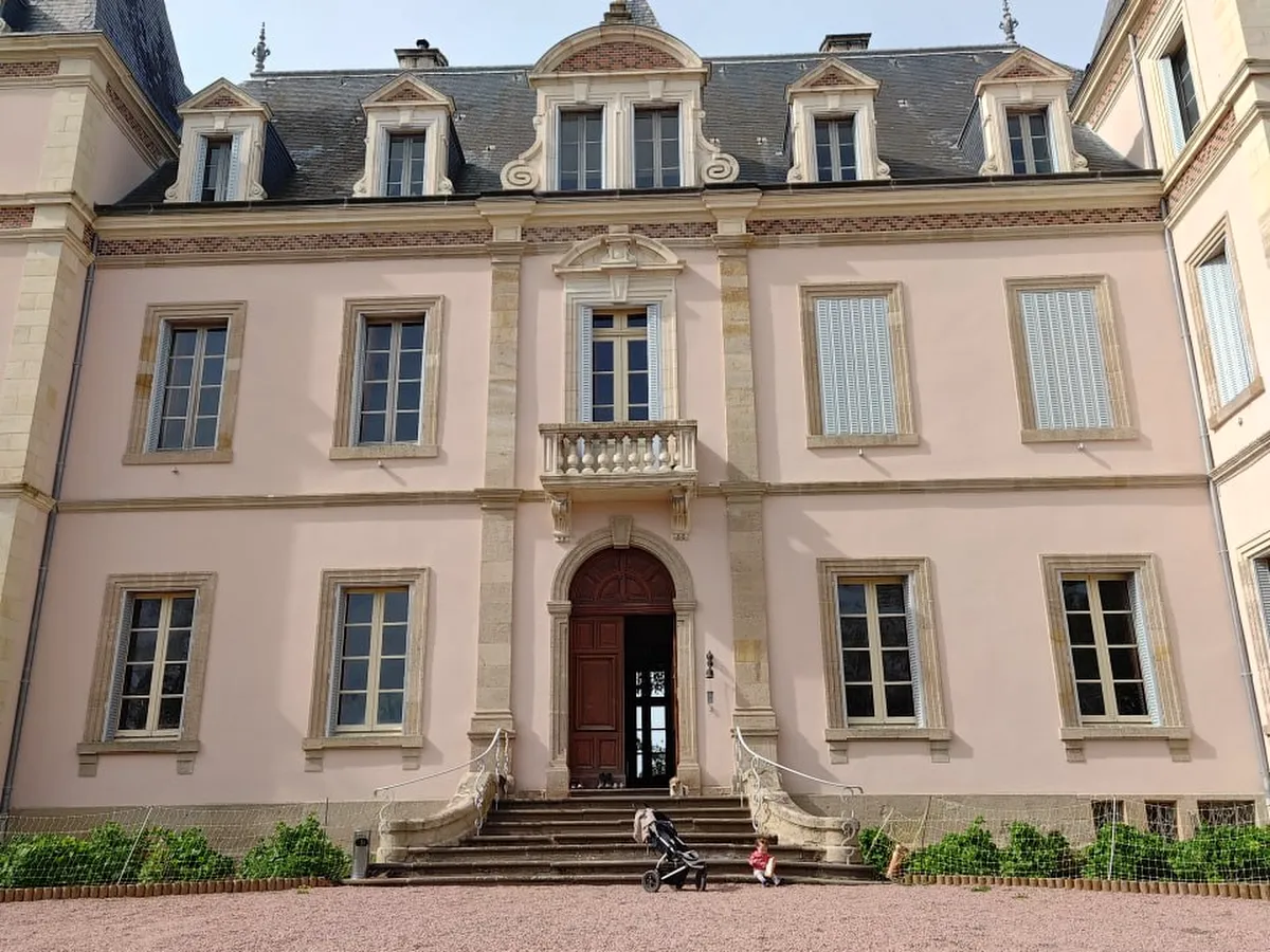 Château façade and outbuildings in clear daytime light
