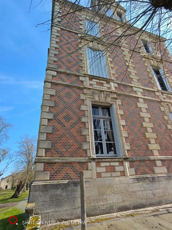 Close view of the diamond-patterned brick and stone facade against a blue sky