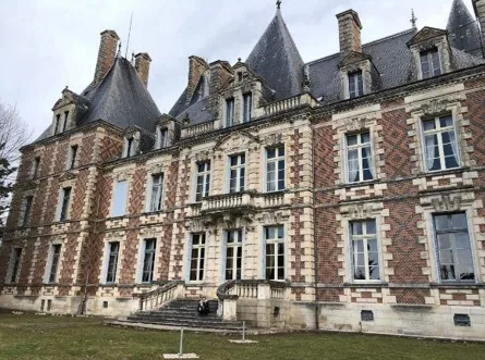 The full brick-and-stone elevation with its dormers and turrets