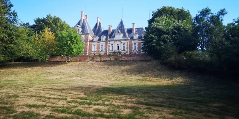 Elevated view of the chateau with open farmland beyond
