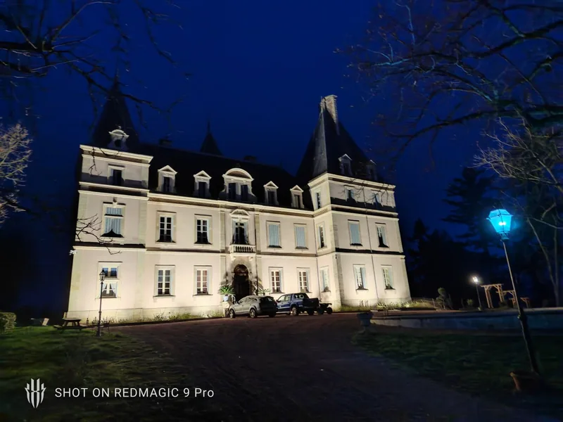 The chateau lit from below against a deep blue evening sky