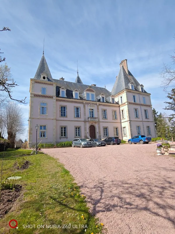 The chateau front seen up the gravel drive in spring