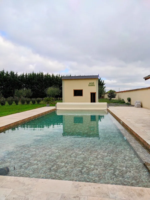 The pool and its pool house framed by clipped hedging