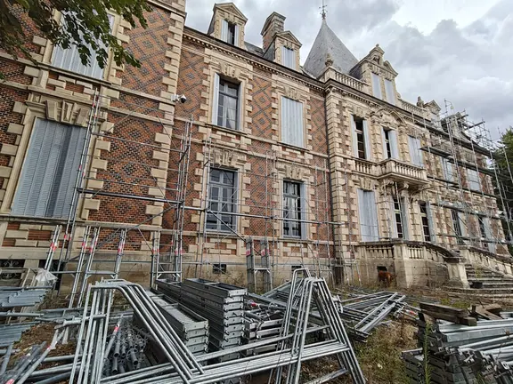 Scaffolding components stacked beside the chateau during works